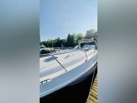 A close-up view of a sleek yacht docked at the marina, showcasing its elegant design and polished exterior under a clear blue sky.