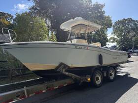 A side view of a Grady-White boat named 'Three Bows' docked on a trailer, showcasing its sleek design and readiness for the water.