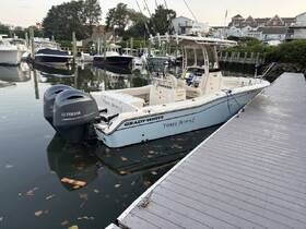 A Grady-White speedboat named 'Three Buoys' docked at a marina, showcasing its sleek design and powerful Yamaha engines — perfect for fishing or cruising.
