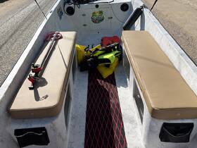 Interior view of a boat showcasing comfortable seating and fishing gear, ideal for a day out on the water.