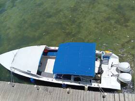 Aerial view of a boat docked at the pier, showcasing its sleek design and blue canopy — perfect for day trips on the water.