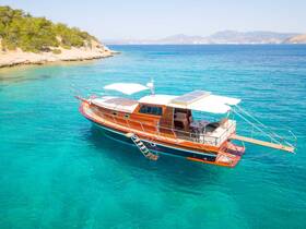 A stunning aerial view of a beautifully crafted yacht anchored in crystal-clear waters, perfect for luxurious getaways and island explorations.