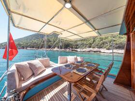 A beautifully arranged dining area inside a boat, featuring comfortable seating and a polished table, perfect for enjoying meals while cruising on serene waters.
