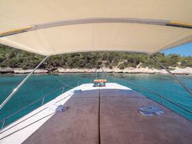 A serene view from the bow of a yacht, showcasing the tranquil turquoise waters and lush greenery along the coastline — perfect for relaxation and scenic cruising.