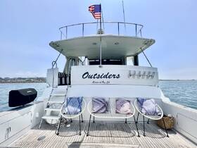 A stunning view of the 'Outsiders' yacht, showcasing its elegant back deck and inviting seating area, perfect for relaxing on the water.
