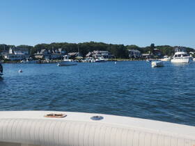 A scenic view of various boats anchored in a calm harbor, showcasing the tranquil beauty of waterfront living.