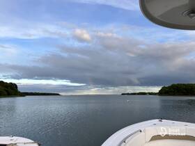 A serene view of a boat's bow with calm waters and a picturesque sky, perfect for capturing the tranquility of a day on the water.