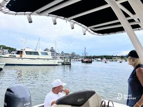 Guests enjoy a scenic view of a marina, observing various boats, including a classic yacht and a pirate ship, creating a lively atmosphere perfect for boating adventures.