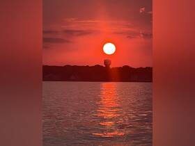 A stunning sunset casts a vibrant glow over the water, creating a picturesque reflection — perfect for capturing the beauty of evening boat trips.