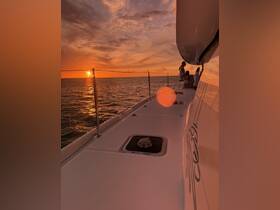 A stunning sunset view from the deck of a boat, with guests enjoying the serene atmosphere — perfect for romantic evenings or sunset cruises.