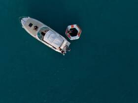 Aerial view of a boat with guests enjoying activities in the water, showcasing the perfect blend of relaxation and adventure on the open sea.