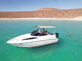 A group enjoys a sunny day on a boat with one person swimming in the clear turquoise waters, showcasing the perfect setting for a fun-filled aquatic adventure.