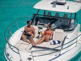 A couple enjoys drinks while sunbathing on the deck of a yacht, surrounded by stunning turquoise waters — a perfect scene for relaxation and romance on the water.