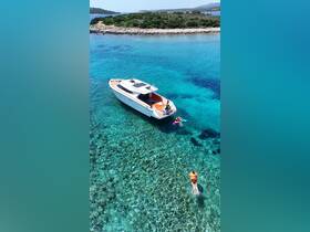 A vibrant scene featuring people enjoying a swim in crystal-clear waters near a stylish boat, perfect for summer adventures and group outings.