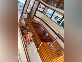Interior view of a cozy boat cabin featuring comfortable seating and a polished wooden table, perfect for relaxing during a day on the water.