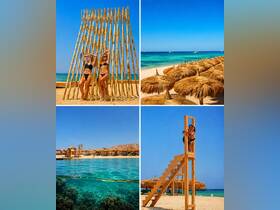 Two friends pose playfully at a beach with vibrant blue waters and straw umbrellas, capturing the essence of summer fun and relaxation.
