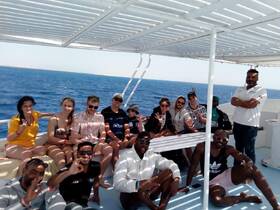 A lively group of friends enjoys their time aboard a boat, capturing the essence of fun and camaraderie on the open ocean.