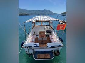 The interior of the boat 'Pajo' features comfortable seating and a table, perfect for relaxing while enjoying the scenic views of the surrounding mountains and water.