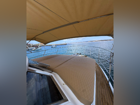 A cozy seating area on a yacht's deck, featuring a shaded canopy and inviting cushions, perfect for relaxing while enjoying the waterfront views.