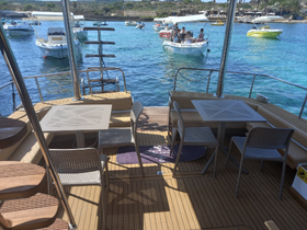 Interior view of a spacious dining area on a boat, featuring comfortable seating and a table, perfect for enjoying meals while cruising on the water.