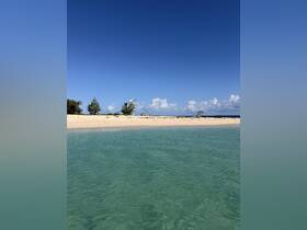 A picturesque beach scene with clear turquoise waters and a sandy coastline, perfect for relaxing and enjoying the beauty of nature.