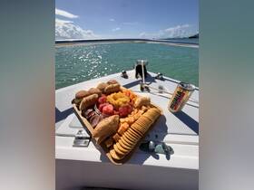 A beautifully arranged charcuterie board featuring a variety of snacks and drinks, perfect for enjoying on a boat trip under the sun.