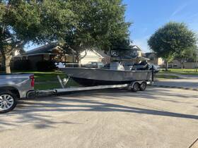 A sleek fishing boat is hitched to a truck, ready for a day on the water. The scene captures the boat's exterior and trailer, set against a suburban backdrop.