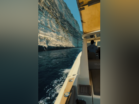 A scenic view of a boat navigating through stunning cliffs, showcasing the beauty of the ocean and the thrill of exploration.