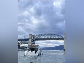 A yacht navigates under a bridge, showcasing the stunning scenery of the waterway — perfect for boating enthusiasts and scenic tours.
