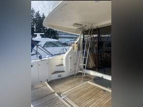 Interior view of a yacht's cabin featuring a stylish wooden deck and a ladder leading to the upper deck, perfect for relaxing or entertaining on the water.