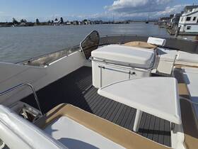 A spacious interior view of a boat's helm and seating area, showcasing a comfortable setup for relaxation and navigation.