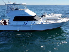 A sleek boat navigates the open waters with guests on board, showcasing a perfect day for a maritime adventure.
