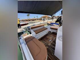 Interior view of a boat featuring comfortable seating and a stylish helm area, perfect for relaxing during a day on the water.