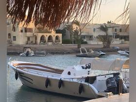 A sleek boat docked by the shore, showcasing its elegant design against a backdrop of coastal architecture and palm trees.