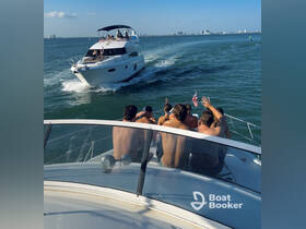 A lively group waves from the back of a yacht as another boat passes by, capturing the essence of a fun day on the water.