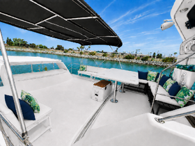 A spacious and stylish interior of a boat featuring comfortable seating and a lounge area, perfect for relaxing while enjoying the scenic waterfront views.