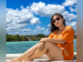 A woman relaxes on the deck of a boat, enjoying the sunny weather and beautiful turquoise waters — a perfect moment for a day out on the water.