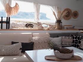 A beautifully decorated interior of a boat featuring cozy seating and stylish decor, perfect for relaxing and enjoying the views while on the water.