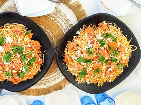 Delicious shrimp pasta served on elegant black plates, perfect for onboard dining experiences or catering during boat trips.