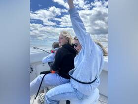 A joyful group of friends enjoys a thrilling boat ride, with one holding a child, capturing the essence of fun and adventure on the water.