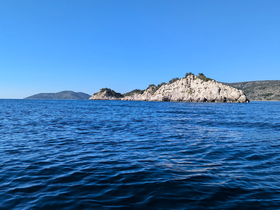 A stunning view of a rocky island surrounded by clear blue waters, perfect for showcasing the natural beauty of coastal destinations.