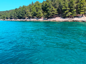 A stunning view of a turquoise coastline, showcasing the natural beauty of the area — perfect for exploring by boat or enjoying a day on the water.
