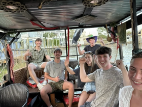 A lively group of friends enjoys a fun moment aboard a boat, showcasing their excitement and camaraderie during a memorable outing.