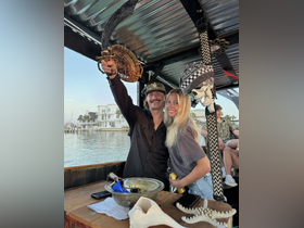 A joyful couple poses aboard a boat, capturing a fun moment with pirate-themed decor — perfect for memorable outings on the water.
