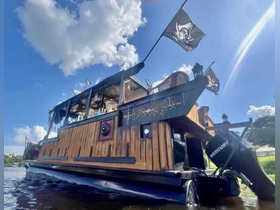 A striking pirate-themed boat glides through the water, showcasing its unique design and flags against a clear blue sky — perfect for themed cruises or parties.
