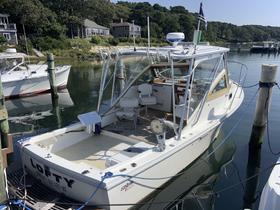 A clear view of the 'LOFTY' boat docked in a serene harbor, showcasing its structure and design against a picturesque backdrop.