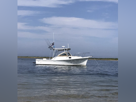 A sleek fishing boat is anchored in calm waters, showcasing its design and fishing gear — perfect for a day on the water.