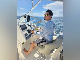 A person navigates from the helm of a boat, showcasing the modern console and comfortable seating — perfect for a day on the water.