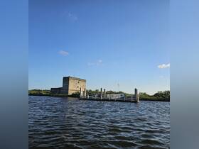 A view of a historical structure by the water, with a dock visible. The image lacks clarity and detail.