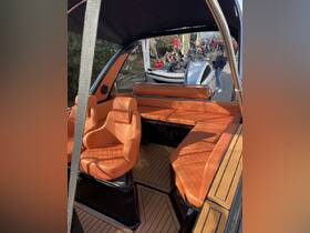 A stylish interior view of a boat featuring plush orange seating and a sleek design, perfect for comfortable cruising.